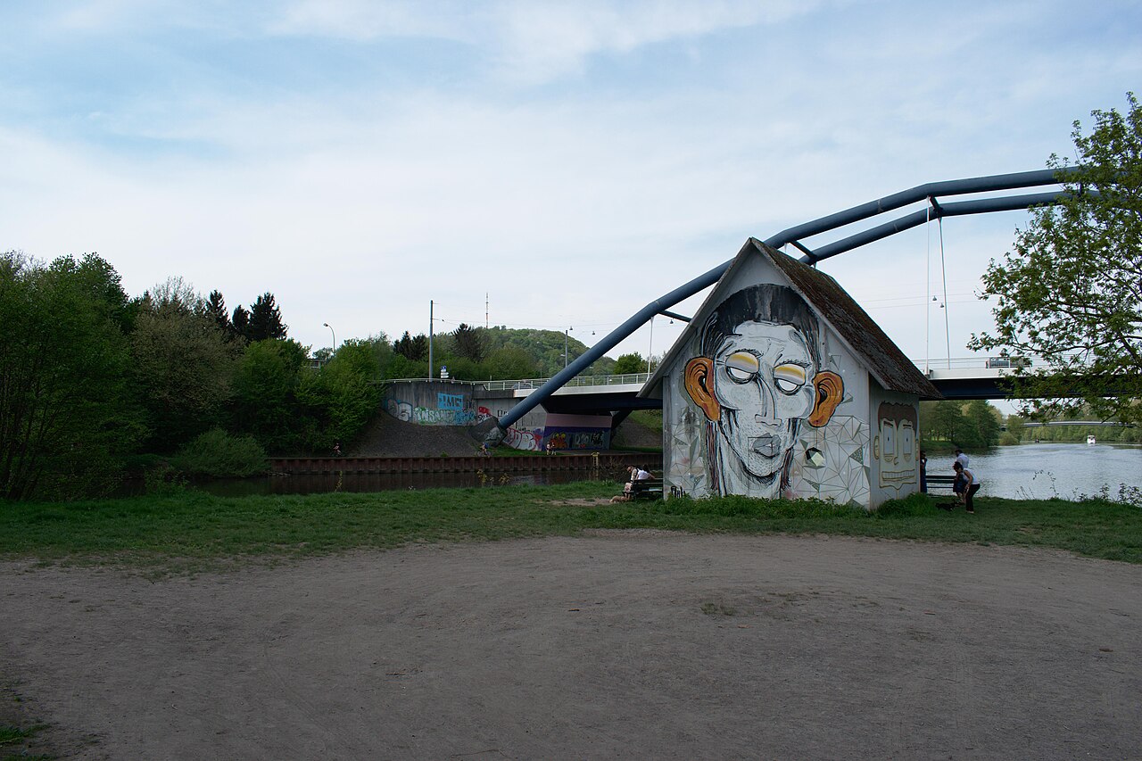 Kunstwerk Die Mühle von Katharina Fritsch, darauf Graffiti und im Hintergrund die Ostspange