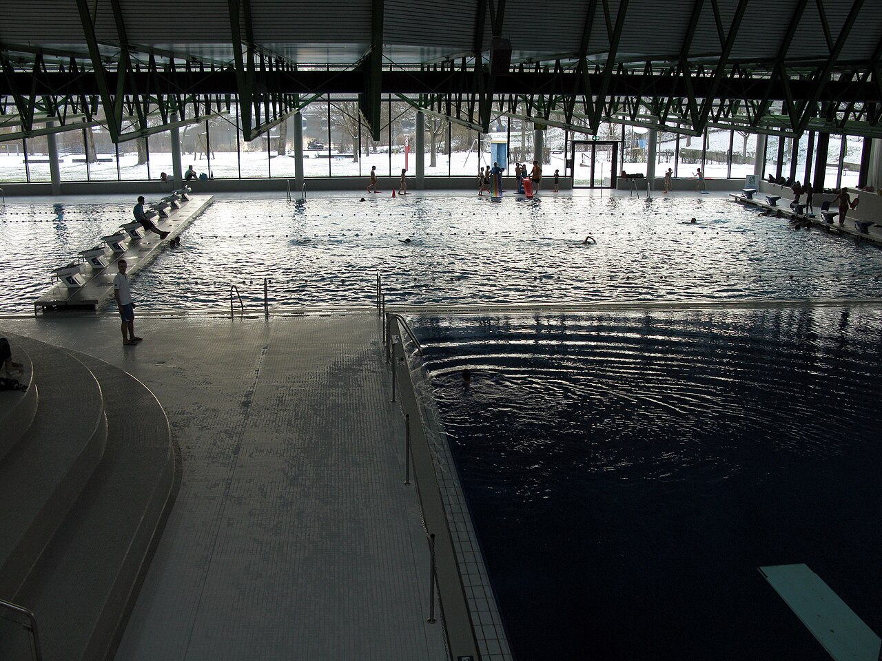 Blick ins Freiburger Westbad, rechts das Springerbecken im Hintergrund das geteilte 50-Meter-Becken