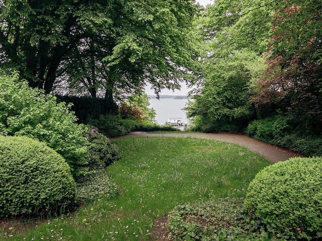 Small lawn with a curved path and a view of the fjord