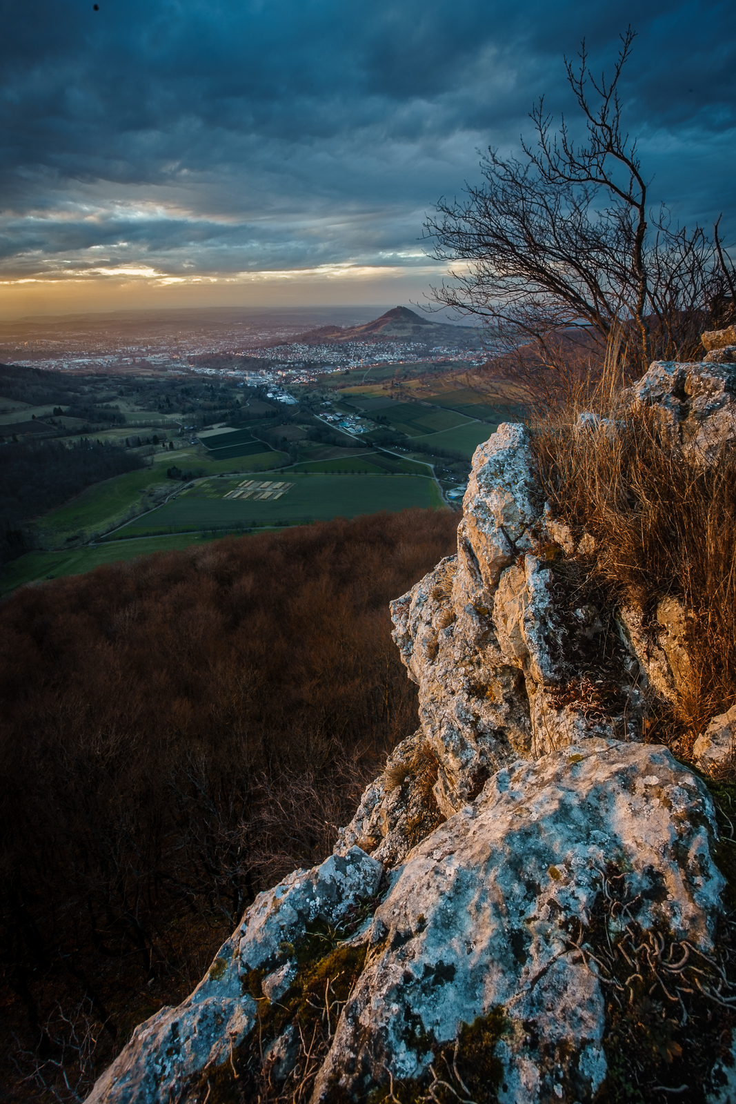 Der Mädlesfels wie er im Sonnenuntergang über Eningen und Pfullingen wacht
