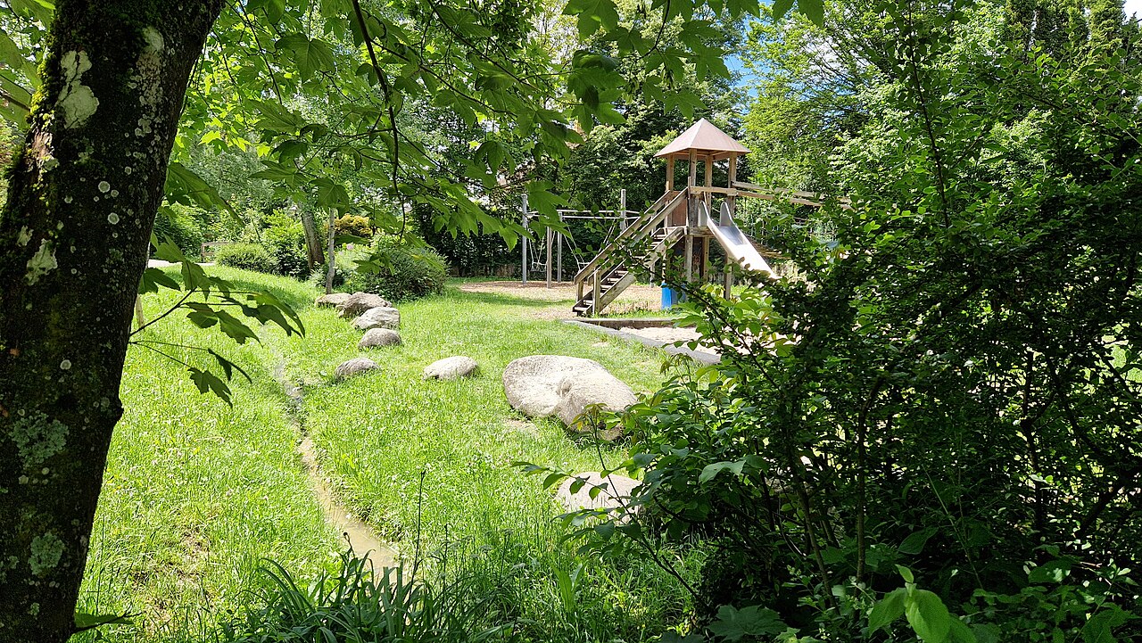 Der Spielplatz Sannentalstraße in Metzingen liegt neben einem kleinen Bach umringt von Büschen und Bäumen