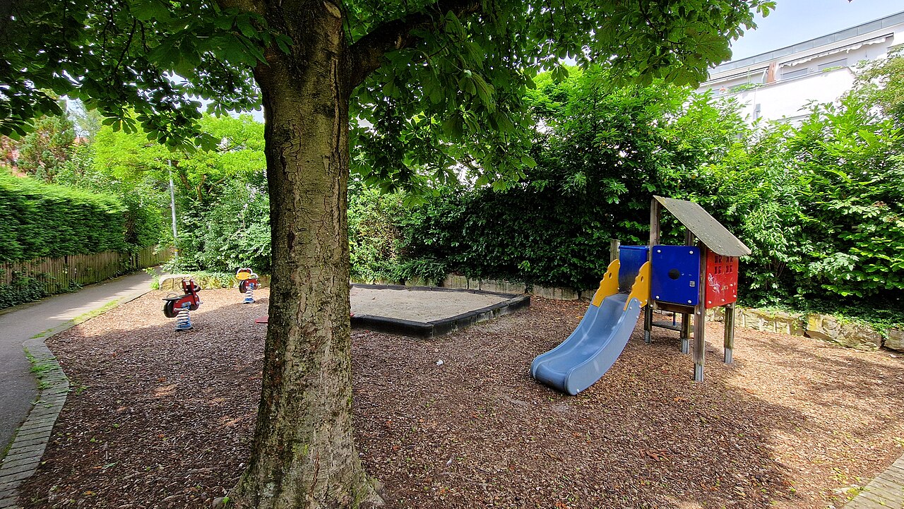 Spielplatz in der Metzinger Innenstadt, der von vielen Bäumen beschattet wird