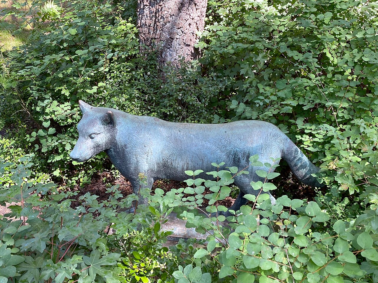 Bronzeskulptur "Wolf" (1970) des Bildhauers Kurt Bauer am Fußweg vor der Wohnanlage Vielohweg 132c in Hamburg-Niendorf